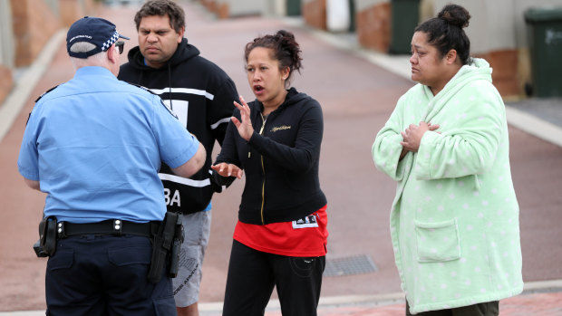 Neighbours speak to police outside the house where  Michelle Petersen and tow of her children were found dead.