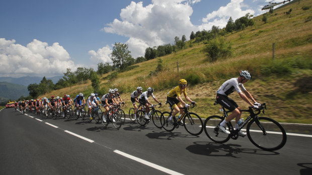 Chris Froome, right, and Geraint Thomas, wearing the overall leader's yellow jersey, climb Col du Portet pass.
