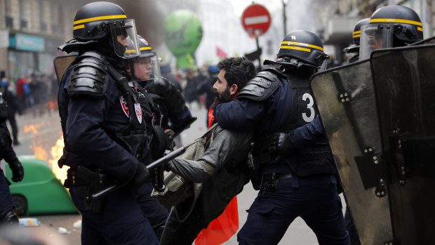 French riot police detain a protester during a rail workers demonstration in Paris,  on Tuesday. French unions plan strikes two days every week through to June.
