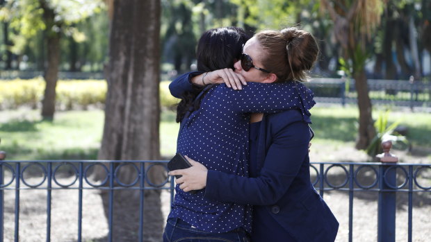 The partner of a member of the crew of a jetliner that crashed in Cuba and another friend, comfort each other in Mexico City, on Friday.