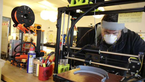 Timothy Prestero, of Design that Matters in Redmond, Washington, watches as one of his 3D printers makes the frame of a medical face shield.