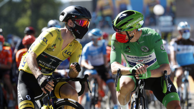 Britain's Adam Yates wearing the overall leader's yellow jersey speaks with Ireland's Sam Bennett, wearing the best sprinter's green jersey at the start of the sixth stage of the Tour de France.