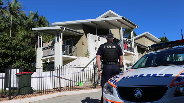 A police officer stands at the units in Osborne Road, Mitchelton.