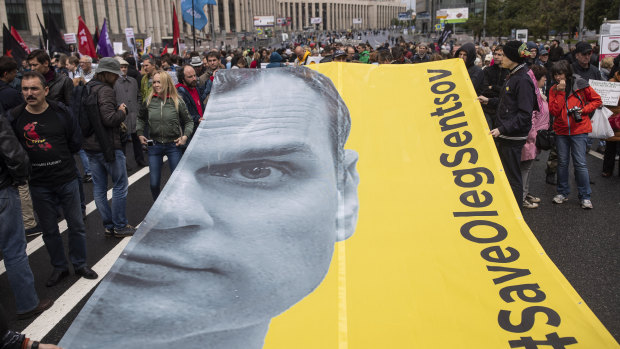 Protesters hold a poster with the image of Oleg Sentsov in Moscow.