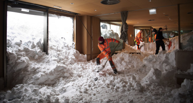 People clear snow from inside the Hotel Saentis in Schwaegalp, Switzerland on Friday after an avalanche swept into the hotel.