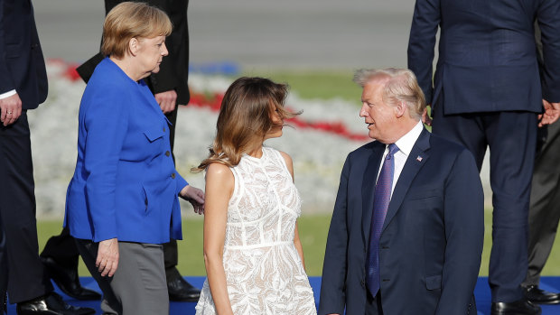 President Donald Trump, first lady Melania and German Chancellor Angela Merkel pose for a group photo of NATO leaders in Brussels.