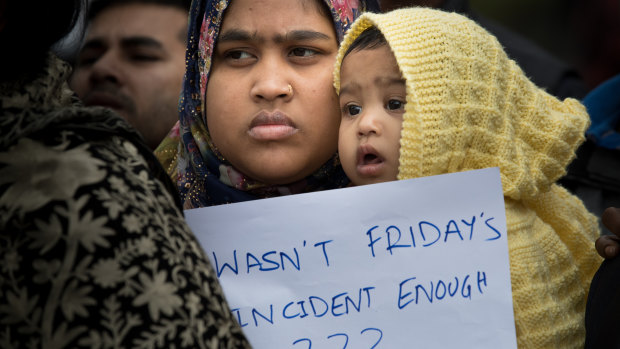 Friends of Missing Bangaladeshi man Zakaria Bhuiyan hold photos outside a refuge center in Christchurch. 