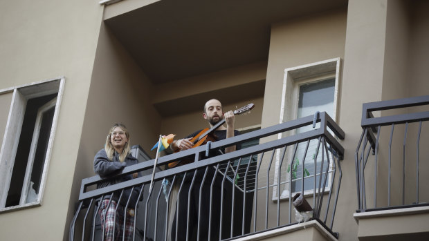 A man in Milan plays guitar on the balcony of his home as part of a flash "non-mob" launched throughout Italy to help people cope with being in lockdown.