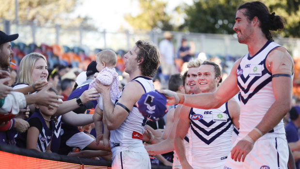 Fremantle players celebrate with fans in Canberra.