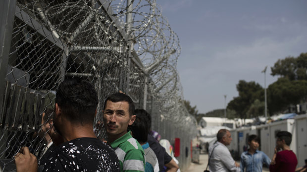 People wait outside the European Asylum Support Service offices inside the camp of Moria earlier this year.