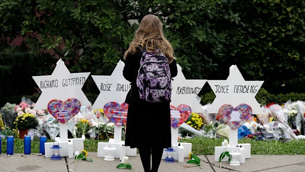 A person stands in front of Stars of David that are displayed in front of the Tree of Life Synagogue.