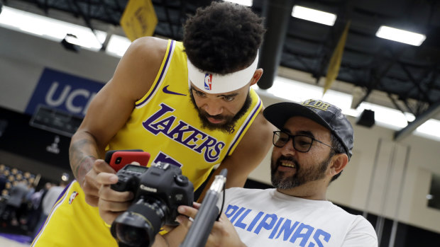 The Lakers' JaVale McGee looks at a photo taken of him at the team's media day.