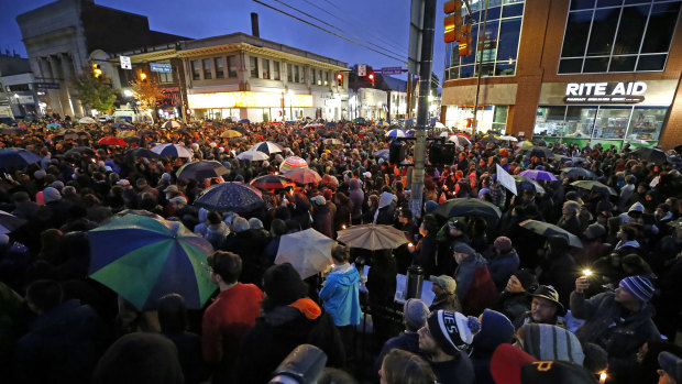 A crowd gathers at the intersection of Murray and Forbes avenues in the Squirrel Hill section of Pittsburgh during a memorial vigil for the victims of the shooting at the Tree of Life Synagogue where a shooter opened fire earlier in the day.