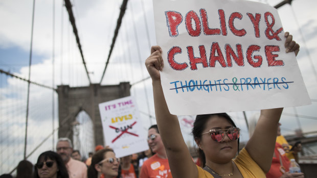Demonstrators carry signs as they march over the Brooklyn bridge during a march and rally against gun violence.