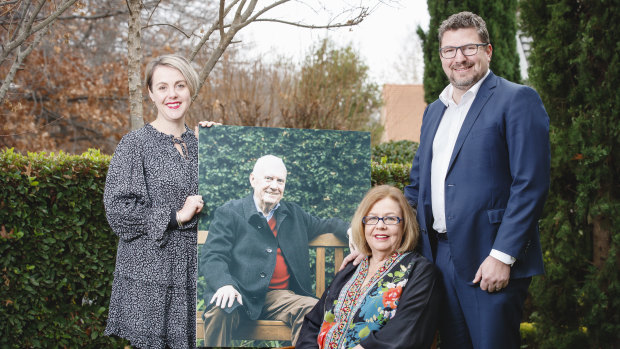 Steve Doszpot's daughter Amy, his widow Maureen and son Adam, with a photo of the late MLA, who has been posthumously awarded a Medal of the Order of Australia.