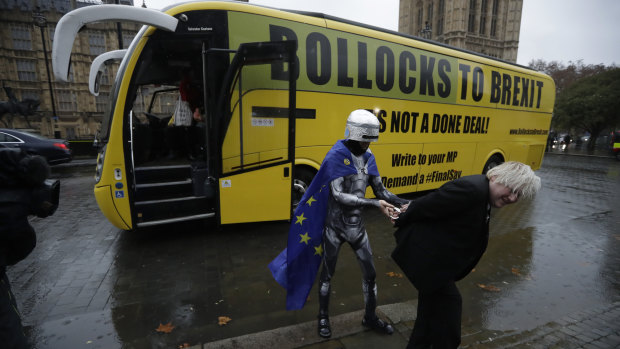 A lookalike for pro-Brexit Member of Parliament Boris Johnson pretends to be arrested by a man dressed as RoboCop as an anti-Brexit "Bollocks to Brexit" campaign bus stands parked outside the Houses of Parliament in London on Friday.