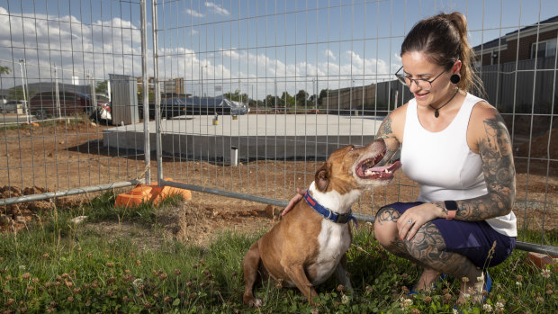 Sam Reichstein and her dog Goose play in front of a block of land that she recently bought in Throsby.