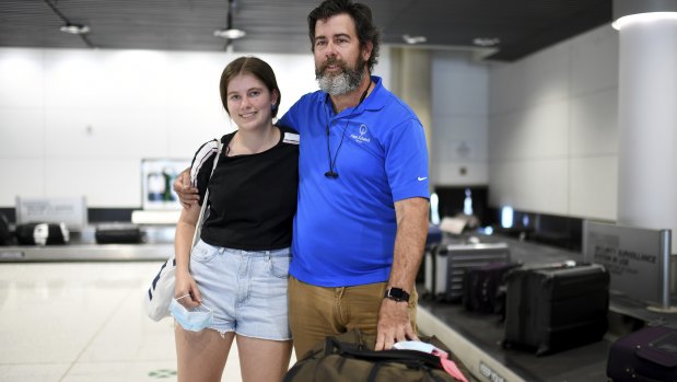 Simon Davis and his daughter Amelie, frustrated after missing a family Christmas, arrive at Brisbane Airport from Wollongong via Sydney on Monday.