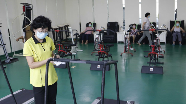 An employee disinfects a treadmill at the Ryugyong Health Complex in Pyongyang, North Kore.