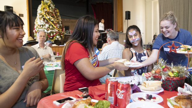 Marieta Pelenato, Anna Uelese, and Wendy Fiti, all from Kaleen, share a laugh with volunteer Nicole Applewhite over Christmas lunch at St John's Care.