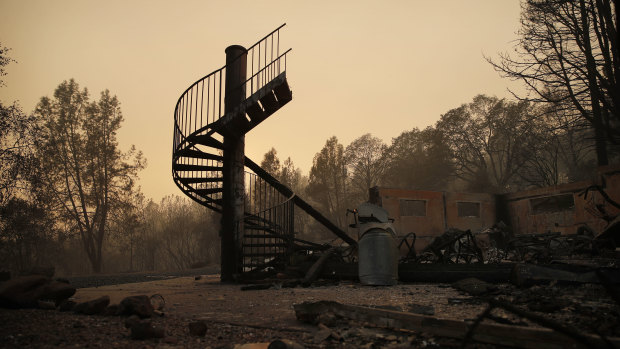 A spiral staircase stands in the remains of a burned out home in Paradise, California.