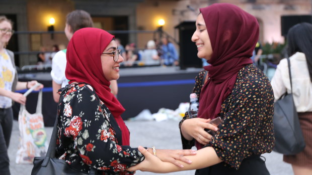 Moments after a stranger embraced Brisbane woman Alham Shebeb (right) after the vigil in show of support.