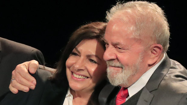 Paris mayor Anne Hidalgo, left, is hugged by former Brazilian president Luiz Inacio Lula da Silva in Paris on Monday.