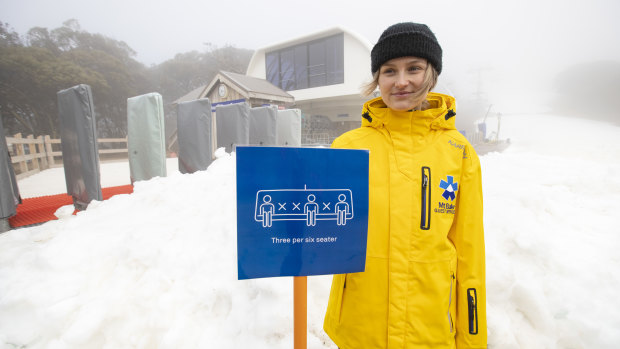 A Mt Buller ski services staff member displays the social-distancing measures the resort was using on its ski lifts.