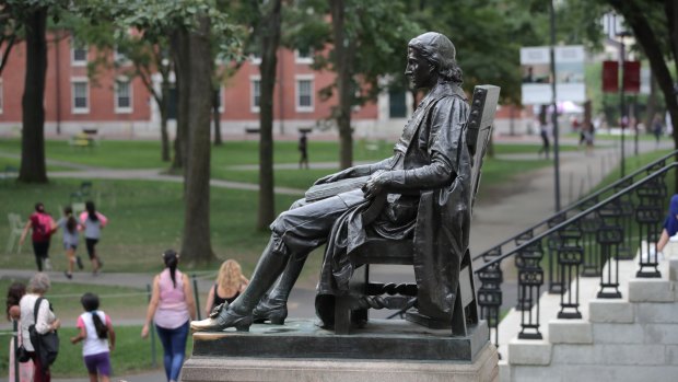 A statue of John Harvard sits in Harvard Yard at Harvard University.