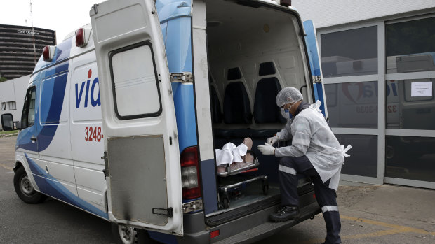 A healthcare worker waits in the ambulance with a patient to enter a public hospital in Brasilia, Brazil.