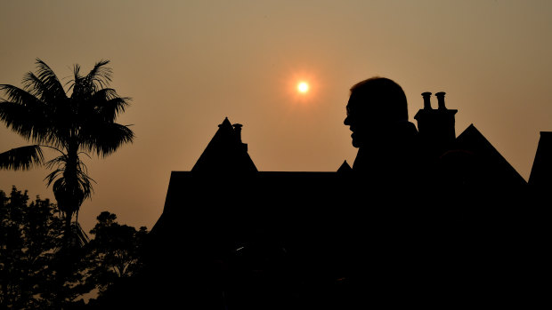 Scott Morrison silhouetted by a smoky sunset over Kirribilli this month. 