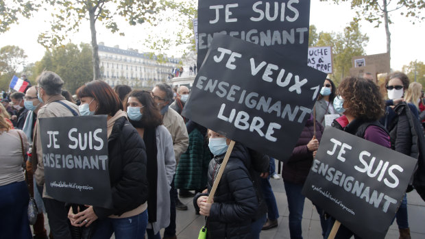 Demonstrators hold placards reading "I am a teacher" and "I want a free teacher" in Paris on Sunday.