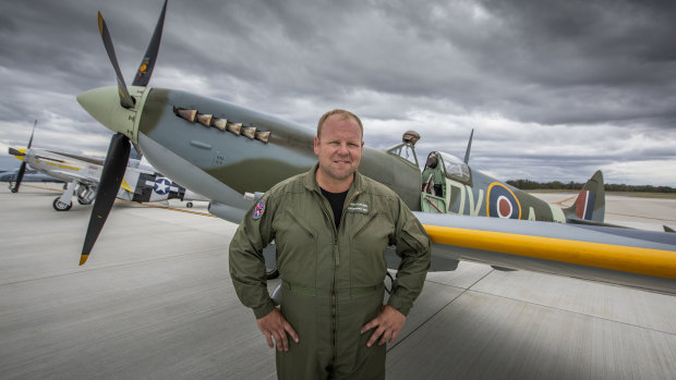 Spitfire pilot Cameron Rolph-Smith poses in front of a restored Spitfire on Brisbane's new runway.