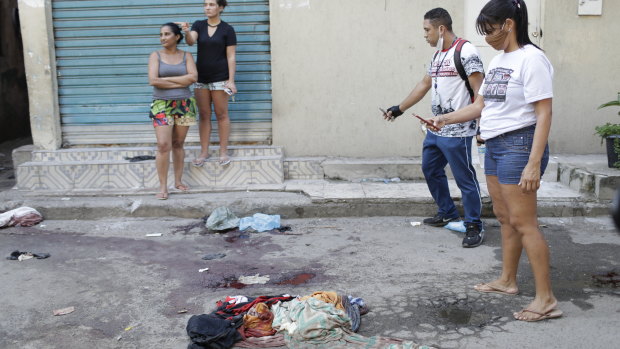Residents take pictures of blood on the street after the shoot-out in the Jacarezinho favela.