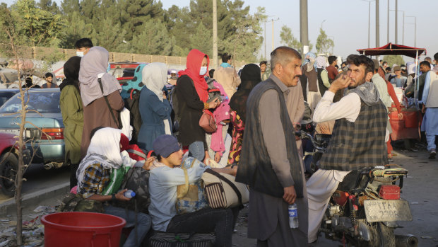 Hundreds of people gather near an evacuation control checkpoint during ongoing evacuations at Hamid Karzai International Airport, in Kabul, Afghanistan.