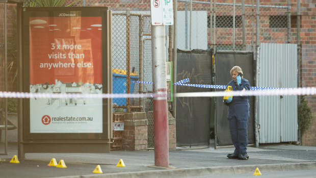 Police at a tram stop in Kew, near where Christopher Polden was stabbed to death.