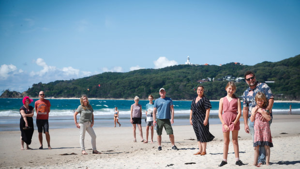 Byron Bay mayor Simon Richardson, his daughters Frida and Matilda with annoyed Byron residents who are worried about the health risks posed by visitors to their town. 