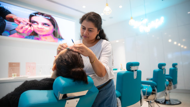 Sohini Trivedi serves a client at one of Ottoman3 Brow Bar's three Melbourne locations. The owner of the  business says it has experienced a 15 per cent drop in sales.