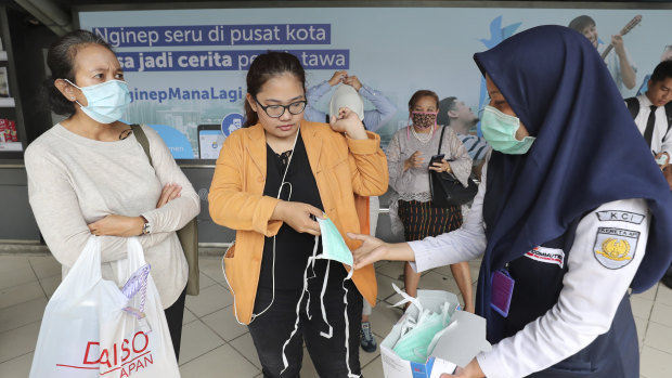 Train officers distributed protective face masks to passengers at a train station in Jakarta, Indonesia. 