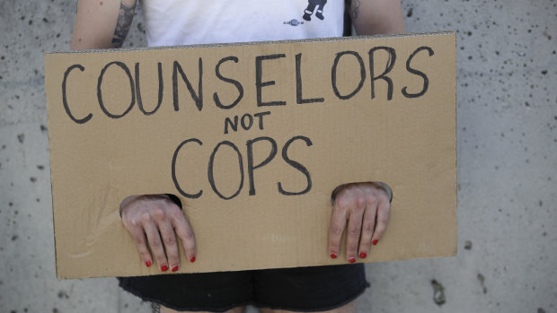 A demonstrator holds a sign during a protest in Los Angeles, where parents, students, and teachers held a press conference and car caravan to call for a safe, fully funded, and racially just approach to reopening schools.