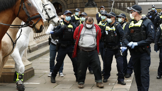 Police arrest a man at the anti-lockdown protest in Melbourne's CBD on Sunday. 