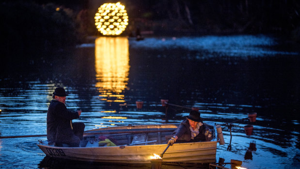 Staff at Compagnie Carabosse light floating fire pots from a paddle boat.