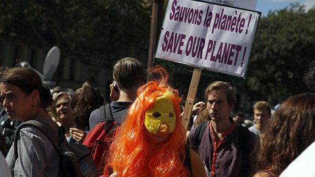 A man holds a poster reading: Save our planet, during a protest in Paris on Saturday.