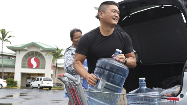 Loren, right, and Ruby Aquino, of Honolulu, load water into their car ahead of Hurricane Lane in Honolulu. 