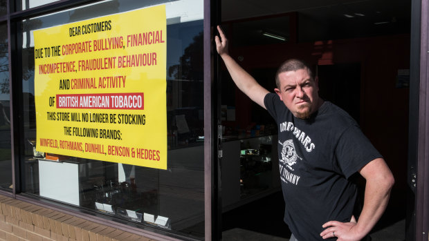 Anthony Rachelle with the sign he has put on his store. 