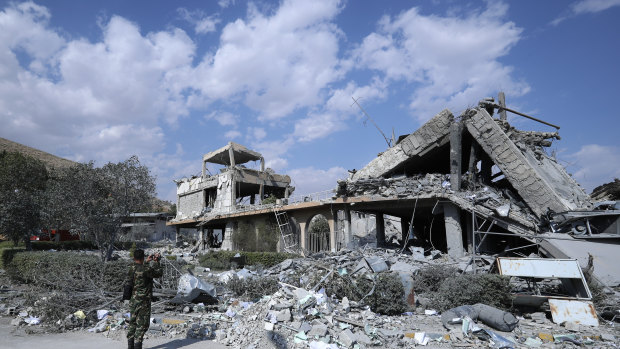 A Syrian soldier films bomb damage at the Syrian Scientific Research Centre.