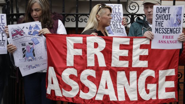 Supporters of WikiLeaks founder Julian Assange stand outside of the Ecuadorian embassy as Assange addresses the media, in London.