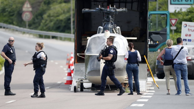 Investigators transport an Alouette II helicopter allegedly abandoned by French prisoner Redoine Faid and suspected accomplices after his escape from prison on Sunday.