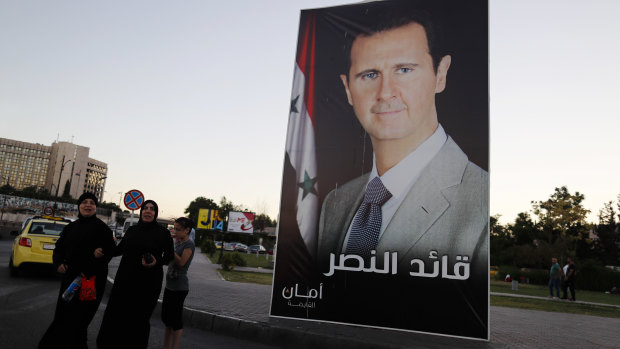 A poster of President Bashar al-Assad with Arabic that reads, "Leader of the victory," hangs on a street at Omayyid Square, Syria. 