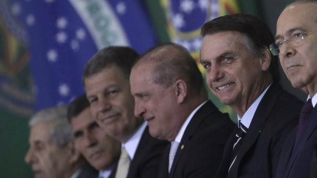 Brazil's President Jair Bolsonaro smiles amid members of his cabinet as he presents them during a ceremony at the presidential palace.